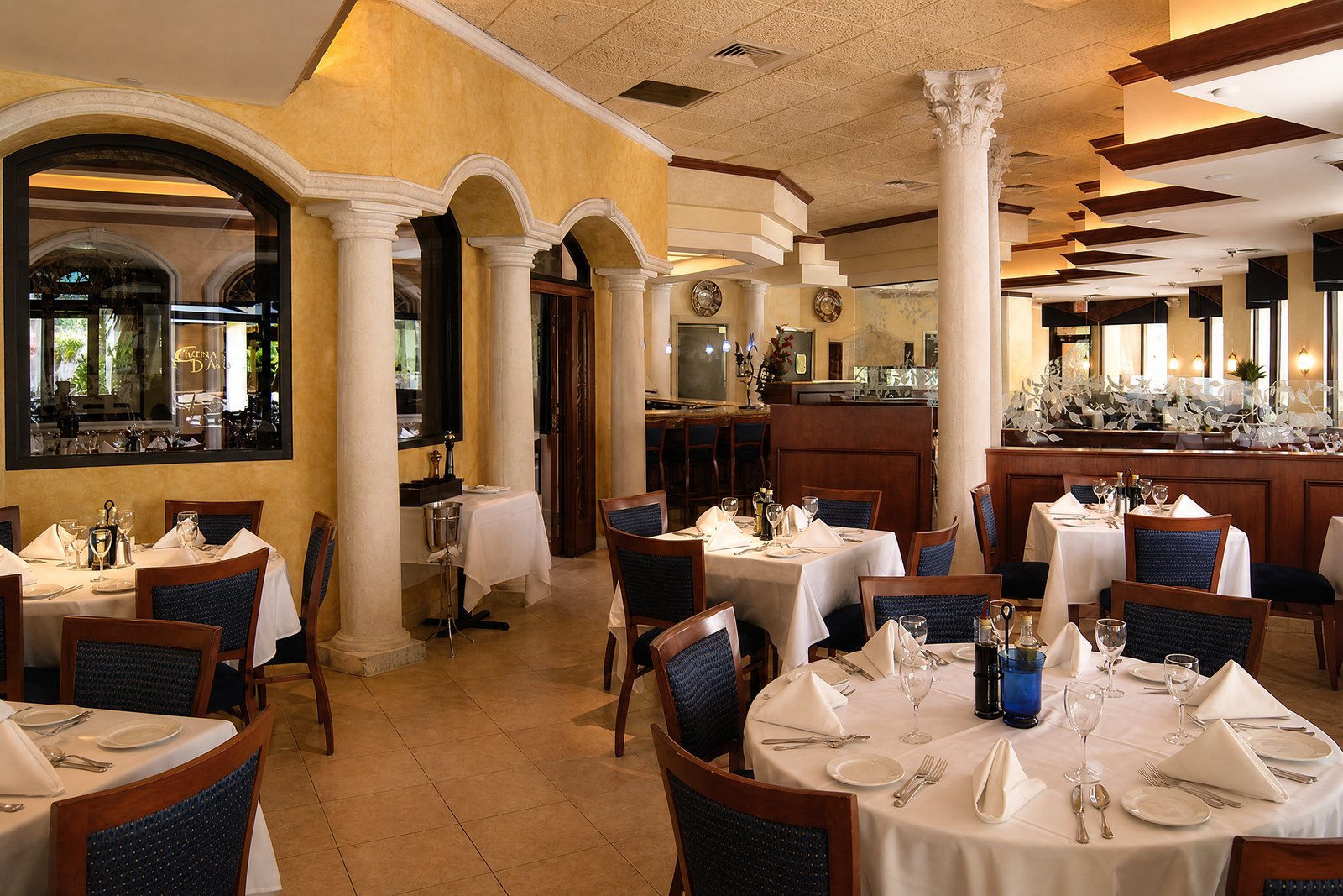 Cuchina D Angelo dining room with arched columns and wood ceiling beams