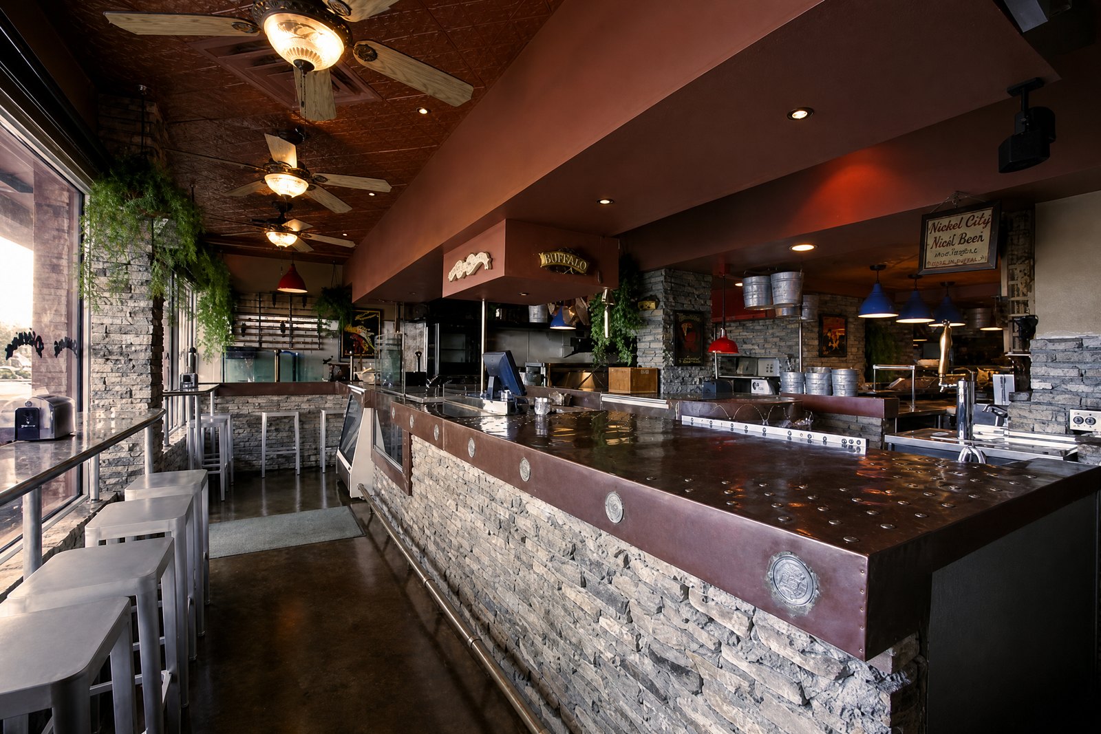 Nickel City bar with dark countertop, stone front and warm lighting